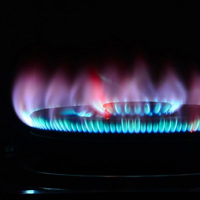 The blue flame of a cooker burner in the dark