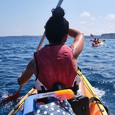 Faceless woman rowing kayak on sea