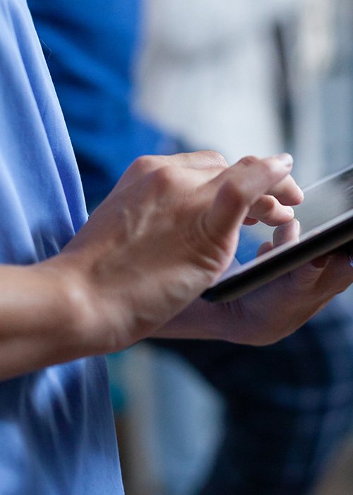 Close up of medical assistant touching tablet display