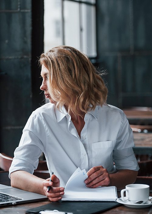 Want to have a walk on the street. Businesswoman with curly blonde hair indoors in cafe at daytime, Want to have a walk on the street. Businesswoman with curly blonde hair indoors in cafe at daytime